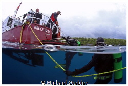 Divers board the dive boat shortly after the passing of a... by Michael Grebler 